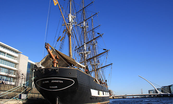 the old-fashioned jeanie johnston boat is anchored in the water in dublin neighbourhood grand canal dock