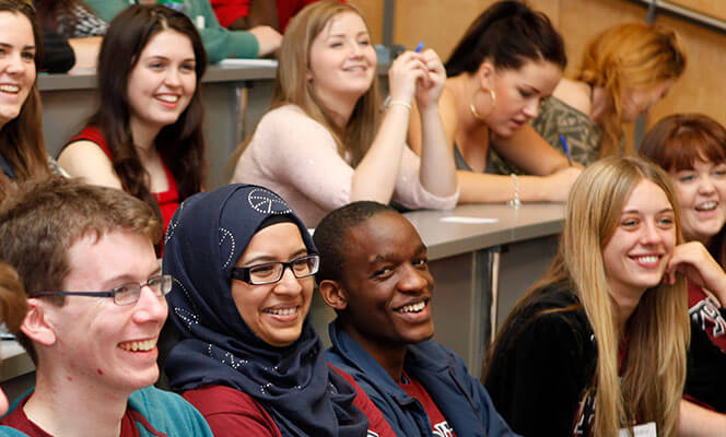 smiling students sit in a lecture hall demonstrating one of the reasons to study in dublin