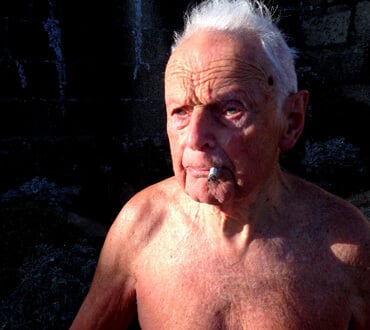 white haired 90 year old man smoking a cigarette at the forty foot