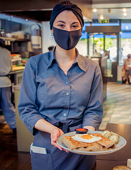 An Anderson's Creperie staff member serving food