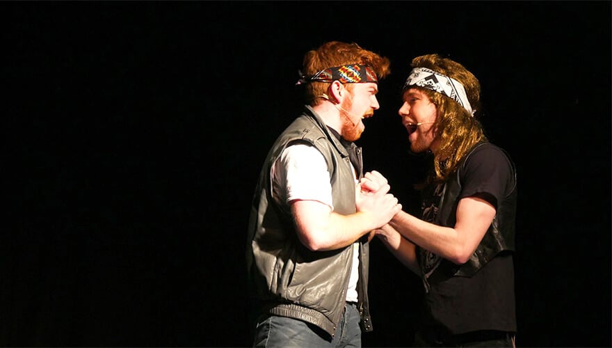 two members of the musical society sing on stage