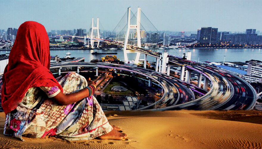 woman sits on desert sand overlooking innovative city