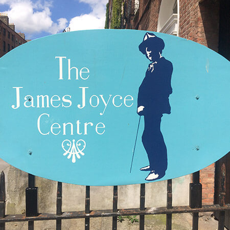 blue sign on the railings of the james joyce centre