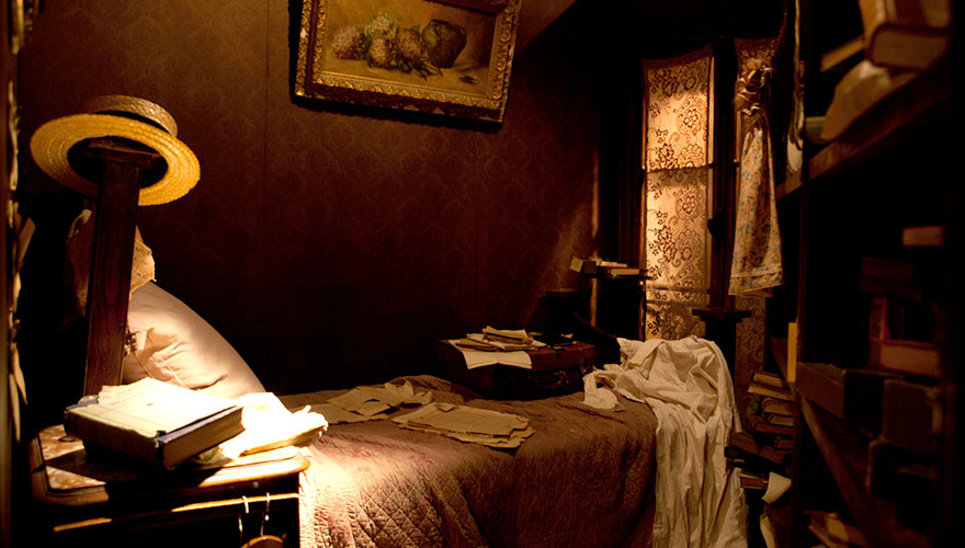 a recreation of james joyce's bedroom complete with hat, books, papers and french screen