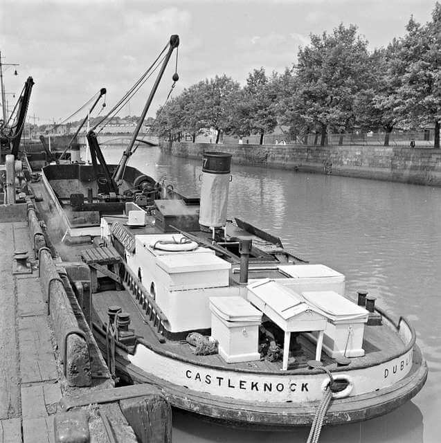 black and white photo of old guinness barge with chimney docked on the liffey